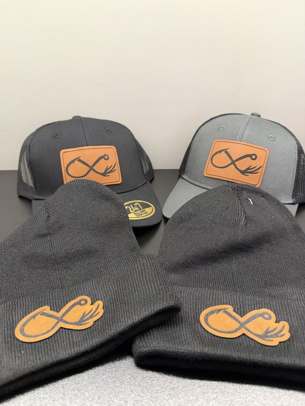 Hats and toques with engraved leather fishing hook patches