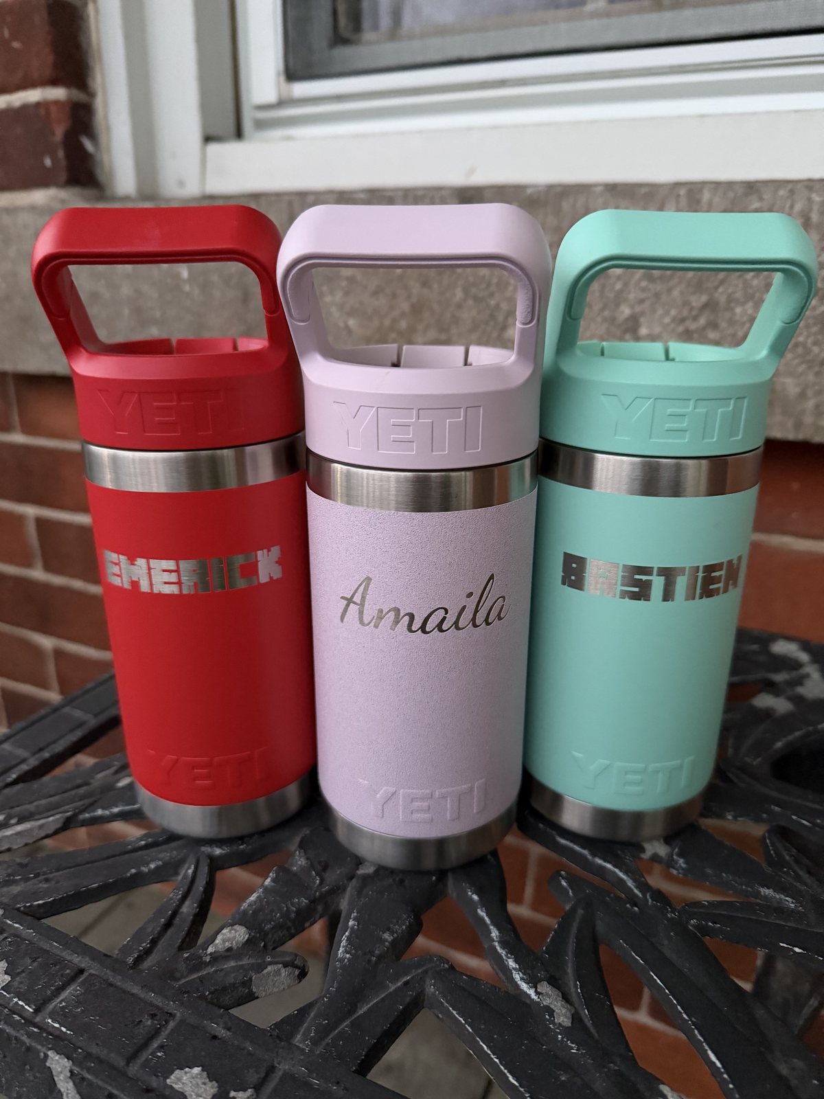 Three Yeti bottles engraved with names